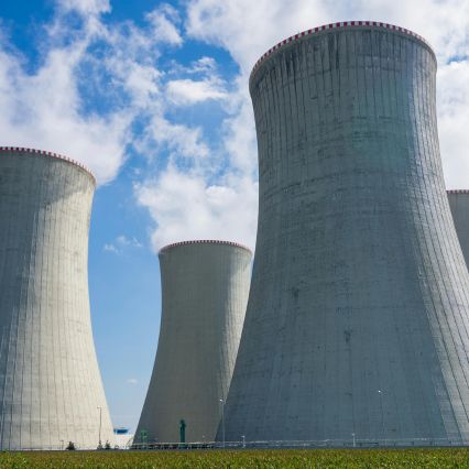 A row of large concrete cooling towers at a nuclear power plant.