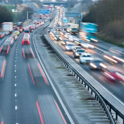 A busy multi-lane motorway with fast-moving traffic in both directions