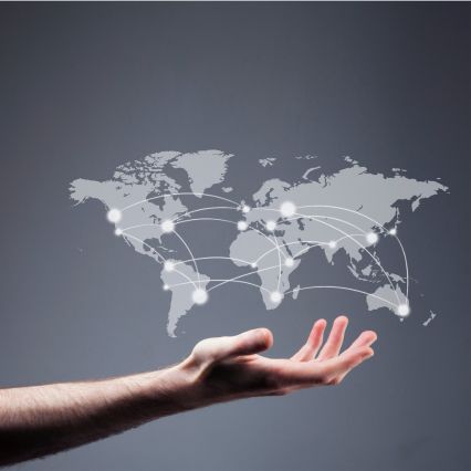 A person's outstretched hand beneath a semi-transparent digital world map.