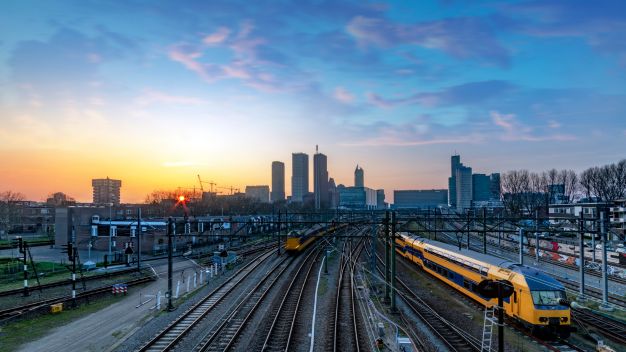 Two trains on track into train station with London skyline