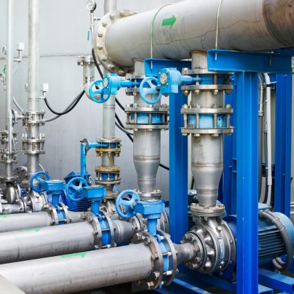 Industrial water treatment pipes and valves inside a facility.